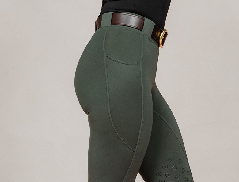 Close-up of women's Umber Green jodhpurs by Freedman Harness, featuring full seat grip and belt – premium equestrian riding apparel