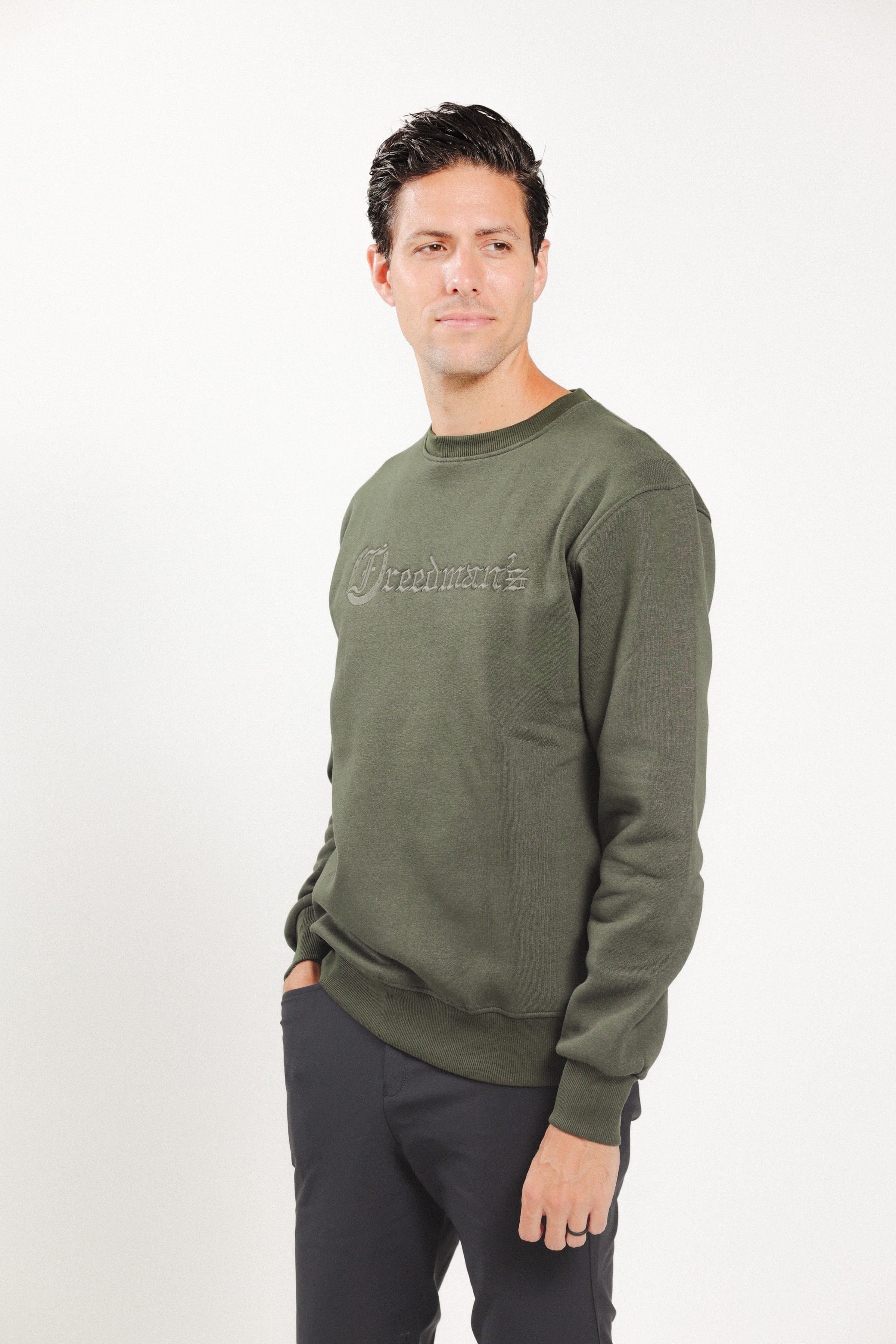 Man wearing Freedman's embroidered crewneck sweatshirts in Green Olive. These stylish and cozy sweatshirts feature a tonal Freedman’s logo, perfect for casual wear and layering