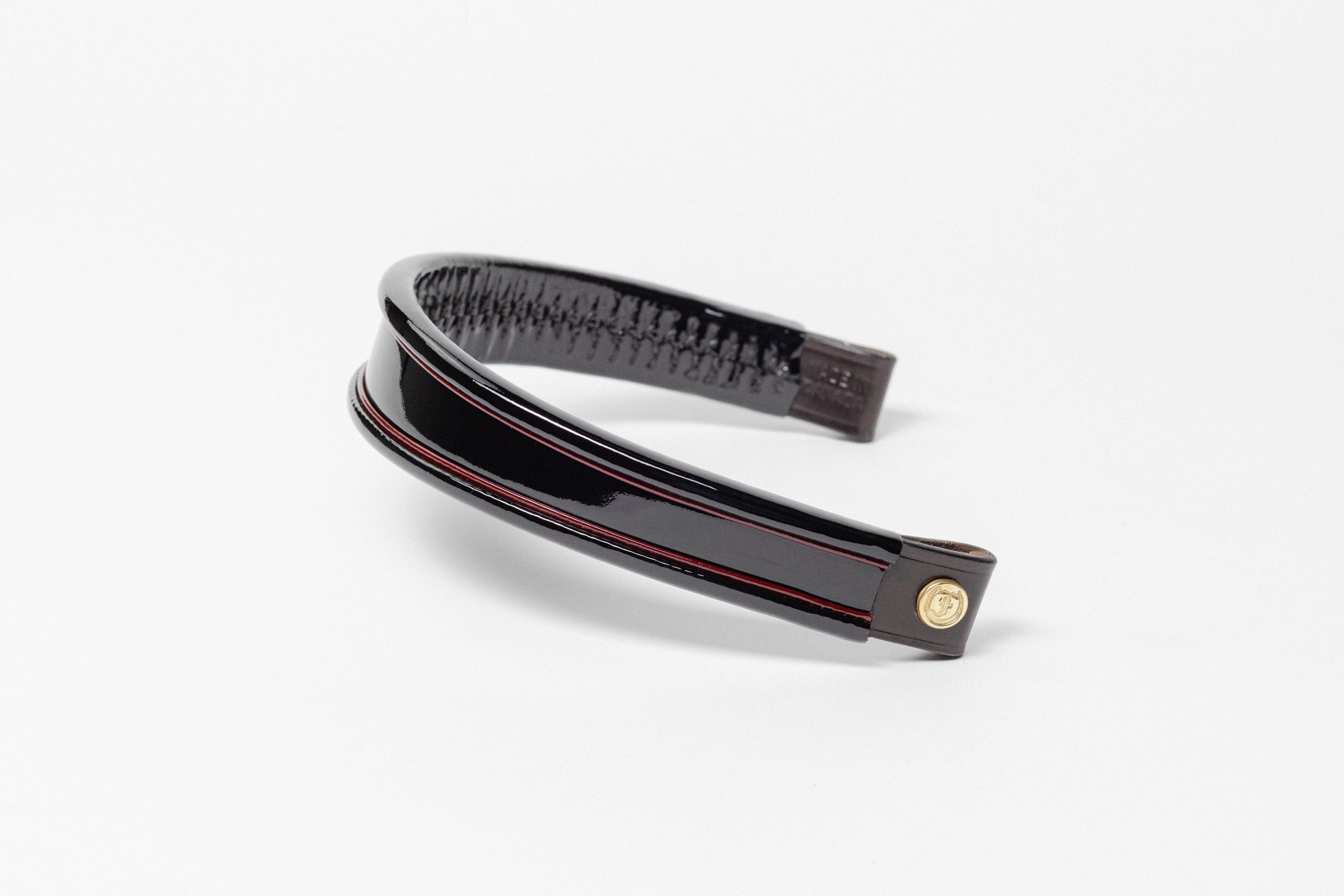 Black and red insert patent leather browband, wide tapered design, turned edge, angled view showing texture and leather ends.