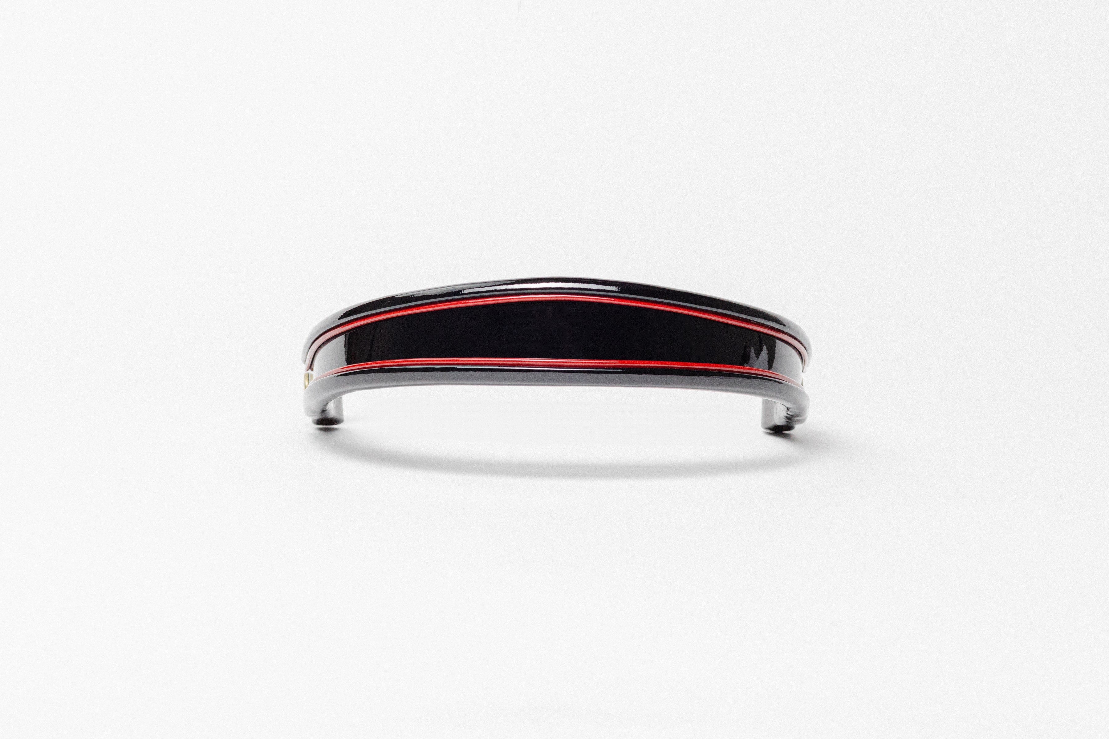 Black and red insert patent leather browband, wide tapered design, turned edge, frontal view showing curved shape