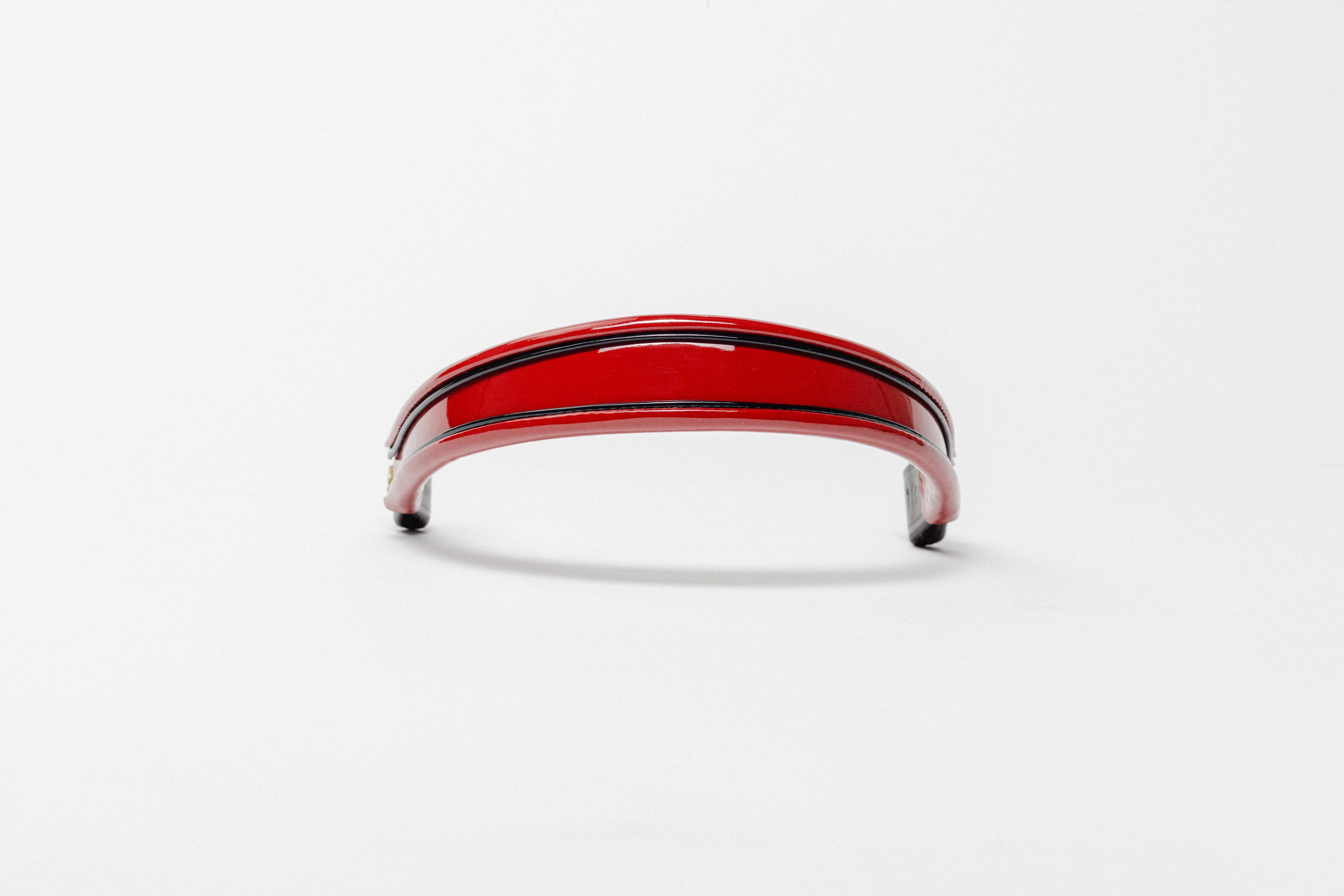Red and black insert patent leather browband, wide tapered design, turned edge, frontal view with visible curve.