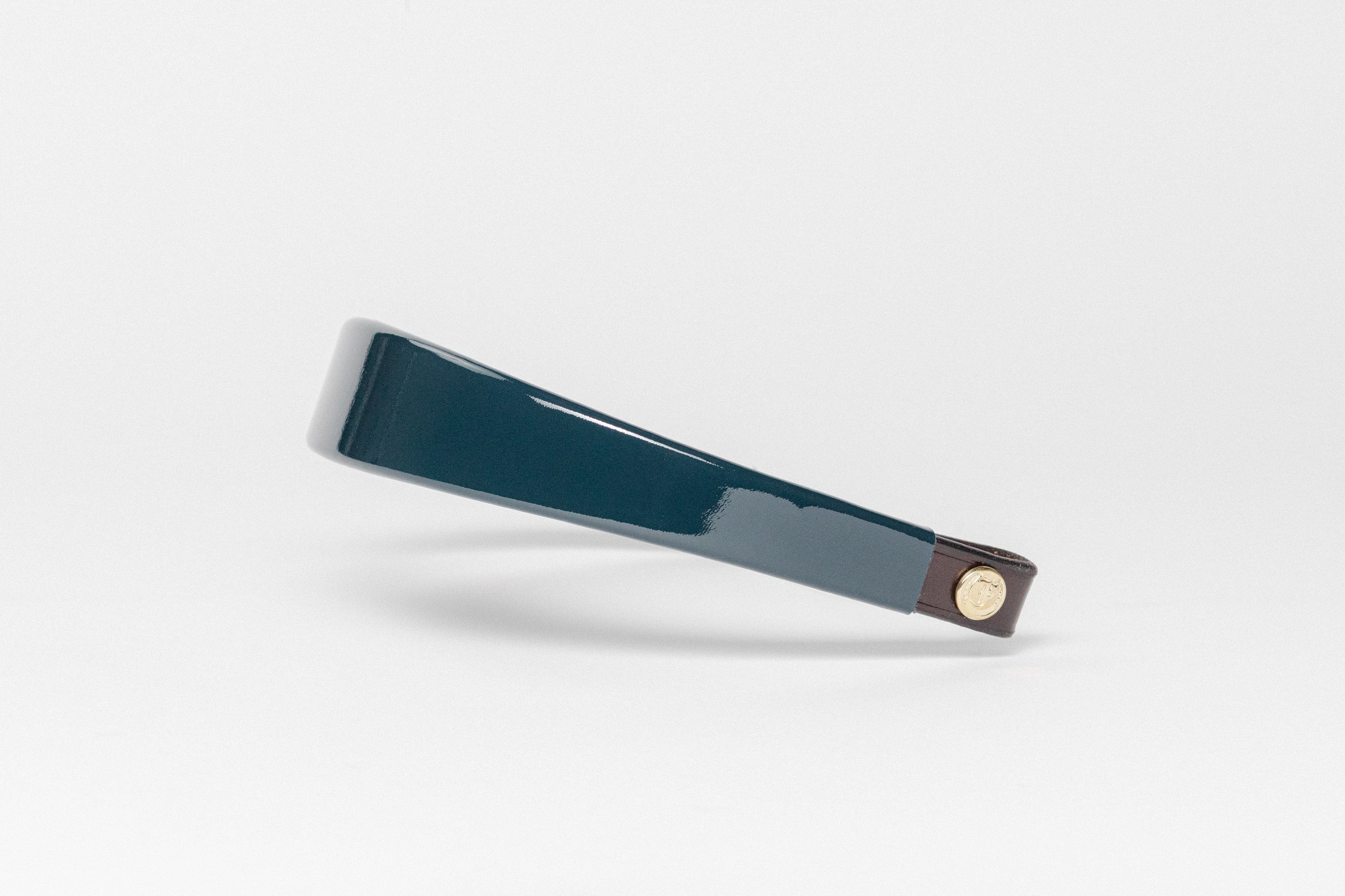 Glossy Navy Blue patent leather browband, wide tapered design, dark leather ends with gold button, angled perspective