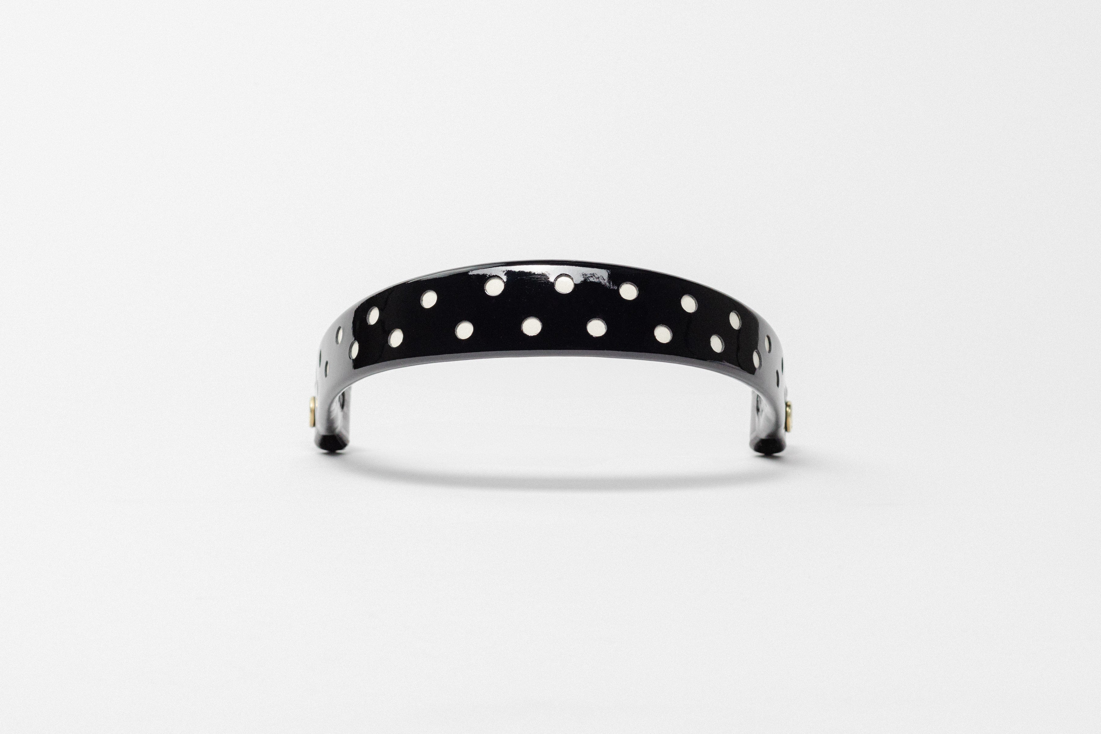 Black Patent Leather Browband with white dots, wide tapered design, polished brass Freedman logo buttons, and dark leather ends, frontal view.