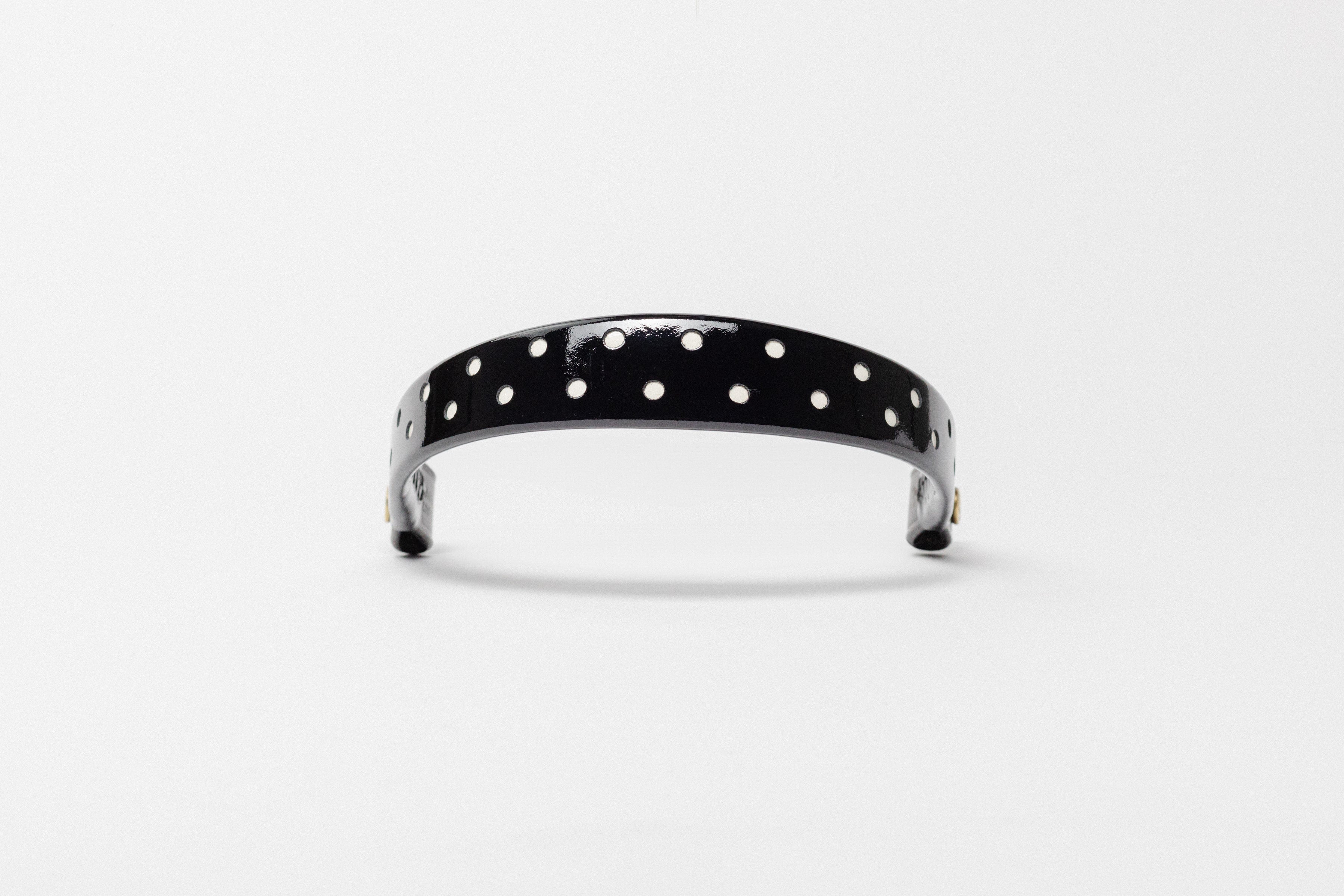 Black Patent Leather Browband with small white dots, wide tapered design, polished brass Freedman logo buttons, and dark leather ends, frontal view.