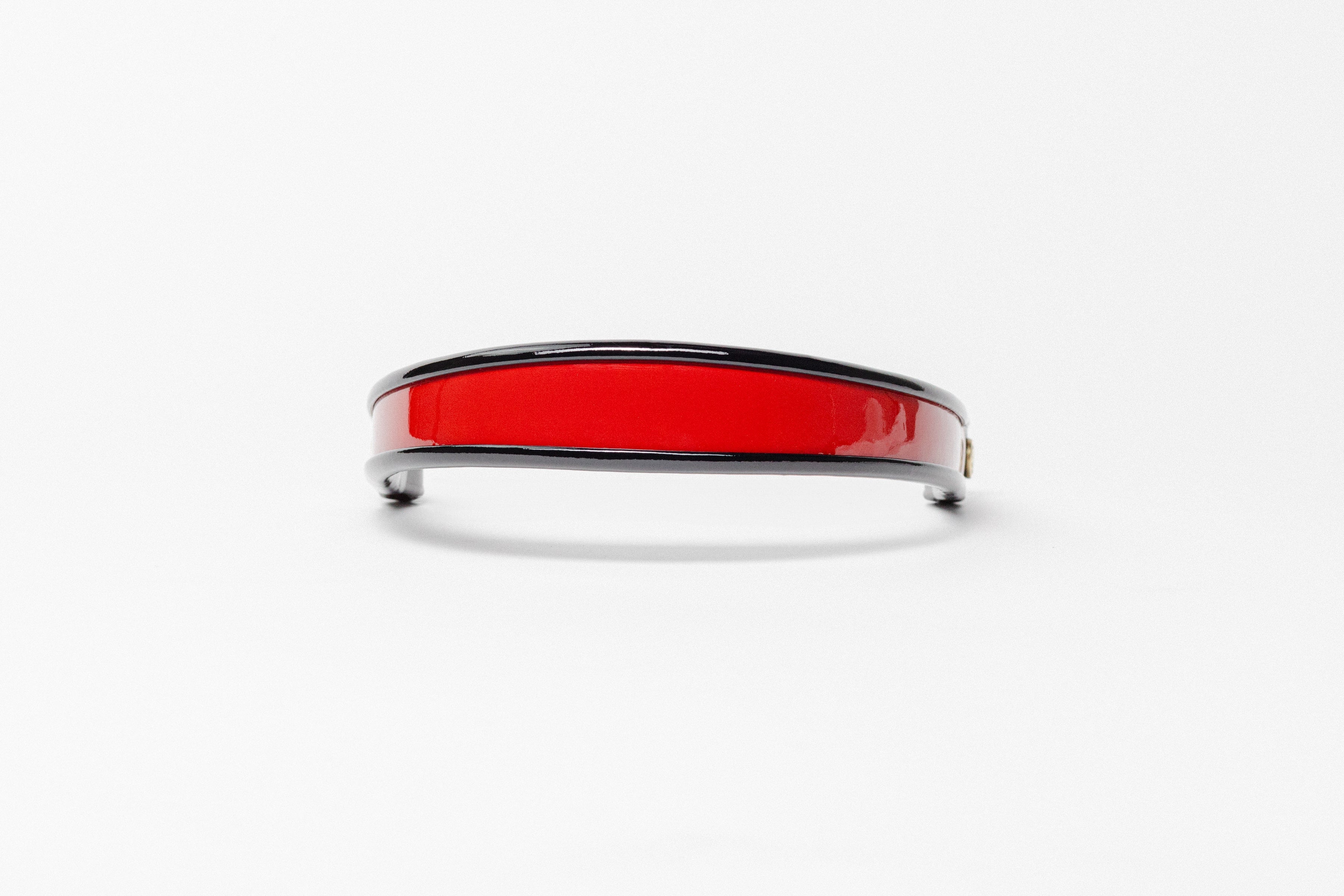 Red and black patent leather browband, wide tapered design, polished brass Freedman logo buttons, and dark leather ends, frontal view.