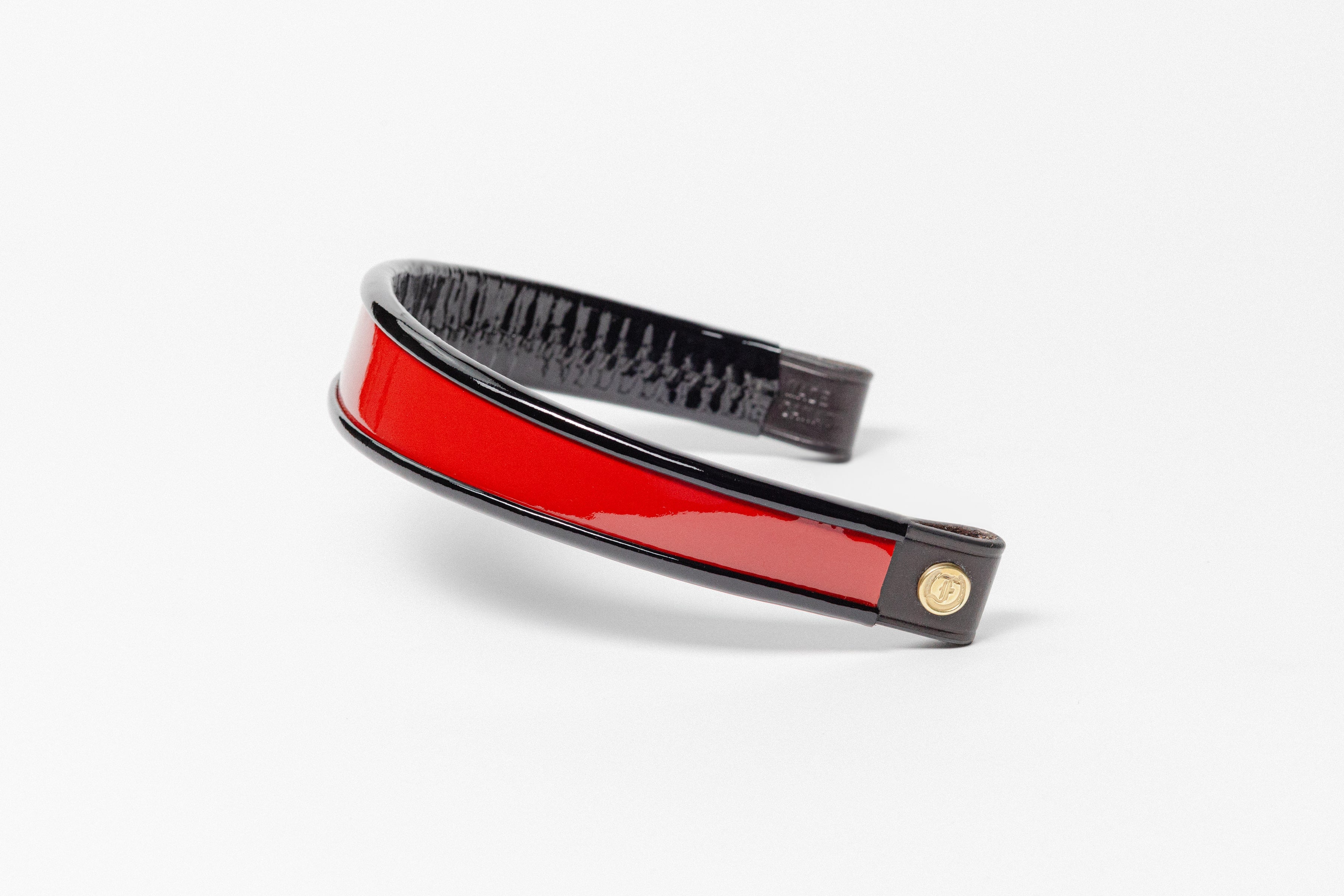 Red and black patent leather browband, wide tapered design, polished brass Freedman logo buttons, and dark leather ends.
