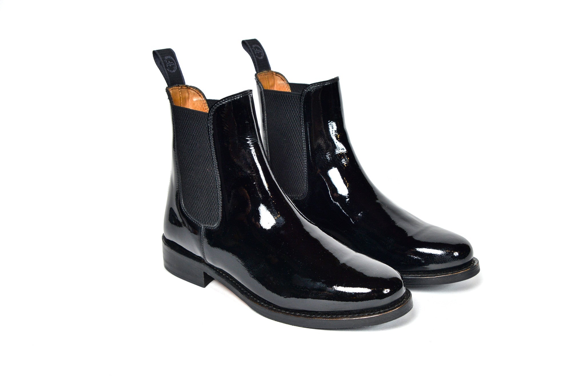 Pair of black patent leather Adelaide Show Jodhpur Boots, isolated on a white background.