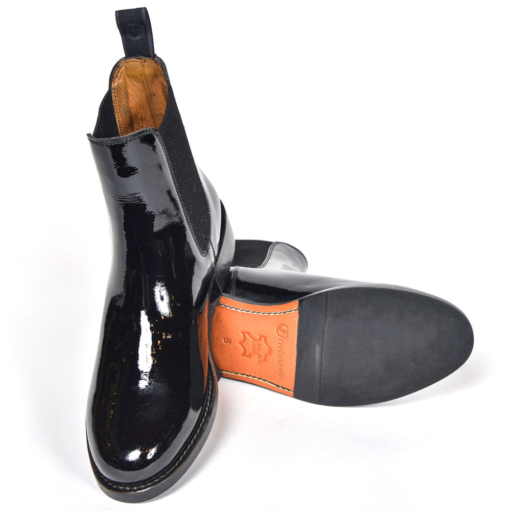 Pair of black patent leather Adelaide Show Jodhpur Boots, showing details including the sole and lining, isolated on a white background