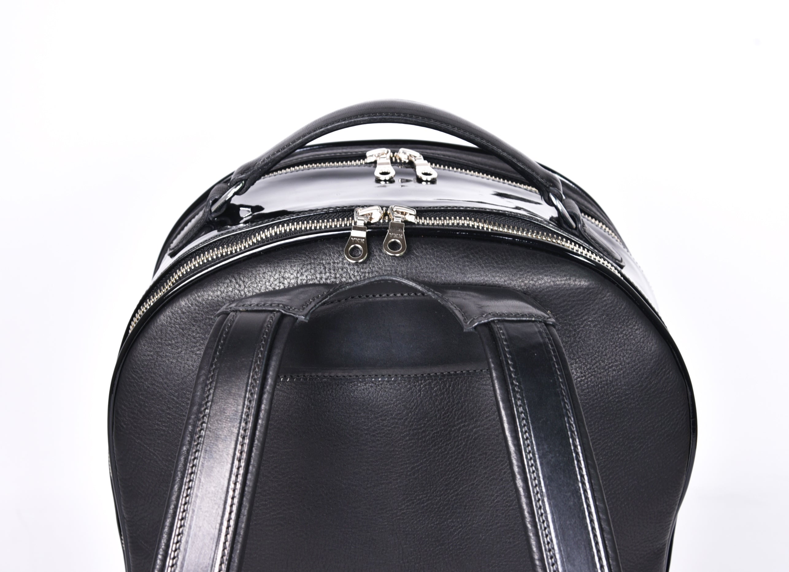 Close-up of black leather backpack, The Jaunty by Freedman's, showing dual zippers, top handle, and shoulder straps