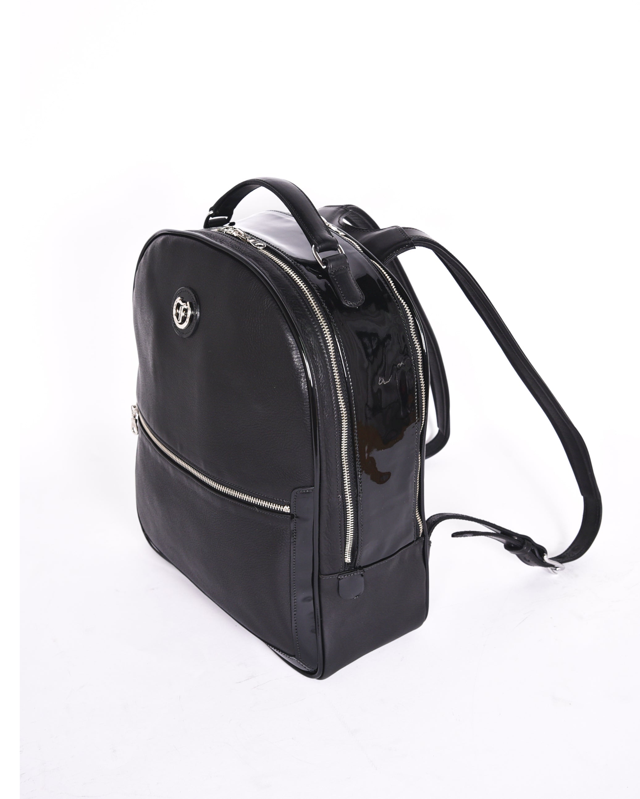 Black leather backpack, The Jaunty by Freedman's, angled perspective with patent leather accent, logo, zippers, and shoulder straps.
