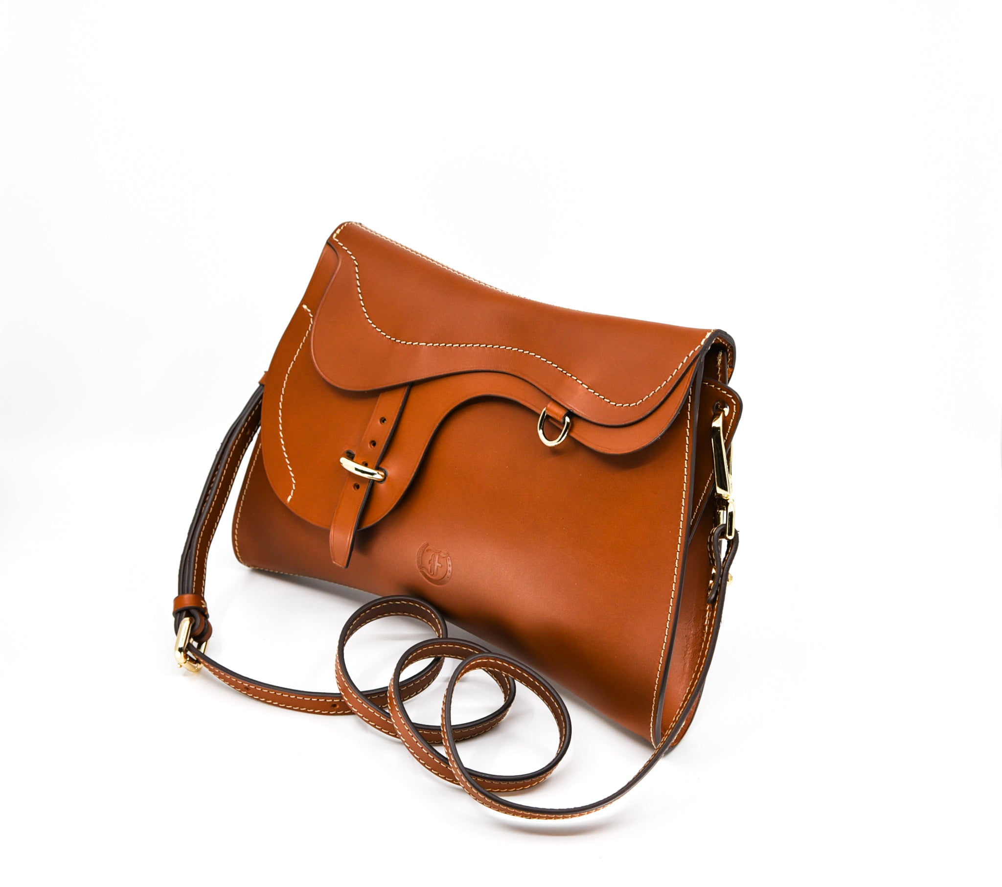 Cognac leather shoulder bag, The Trooper by Freedman's, with saddle flap detail, silver hardware, and light stitching. - angled view.