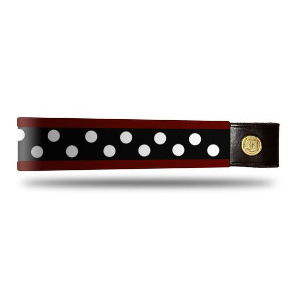 Burgundy and white dot patent leather browband, wide tapered design, turned edge, dark leather ends with gold button, shown flat.