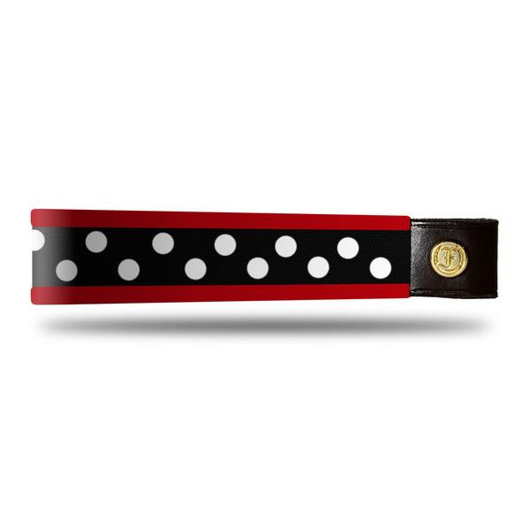Red and white dot patent leather browband, wide tapered design, turned edge, dark leather ends with gold button, shown flat.