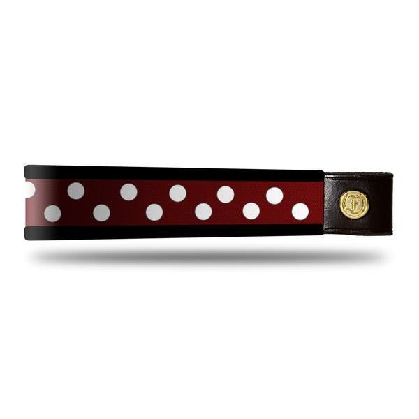 Black and white dot patent leather browband, wide tapered design, turned edge, dark leather ends with gold button, shown flat.
