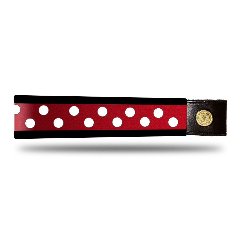Red and white dot patent leather browband, wide tapered design, turned edge, dark leather ends with gold button, shown flat.