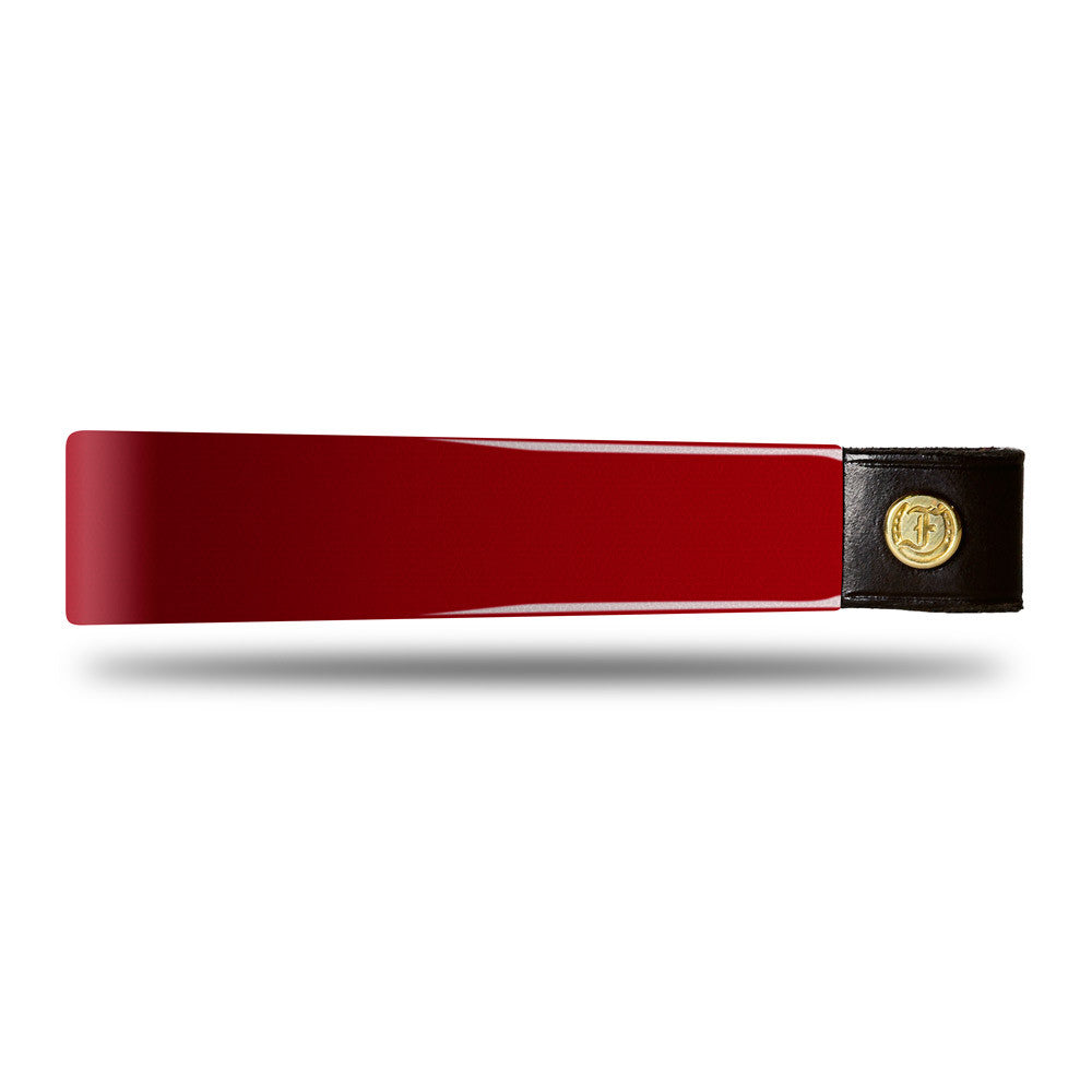 Wide Tapered Patent Leather Browband, glossy red finish, dark leather ends with gold button detail and embossed logo, laid flat on white background, showing smooth surface.
