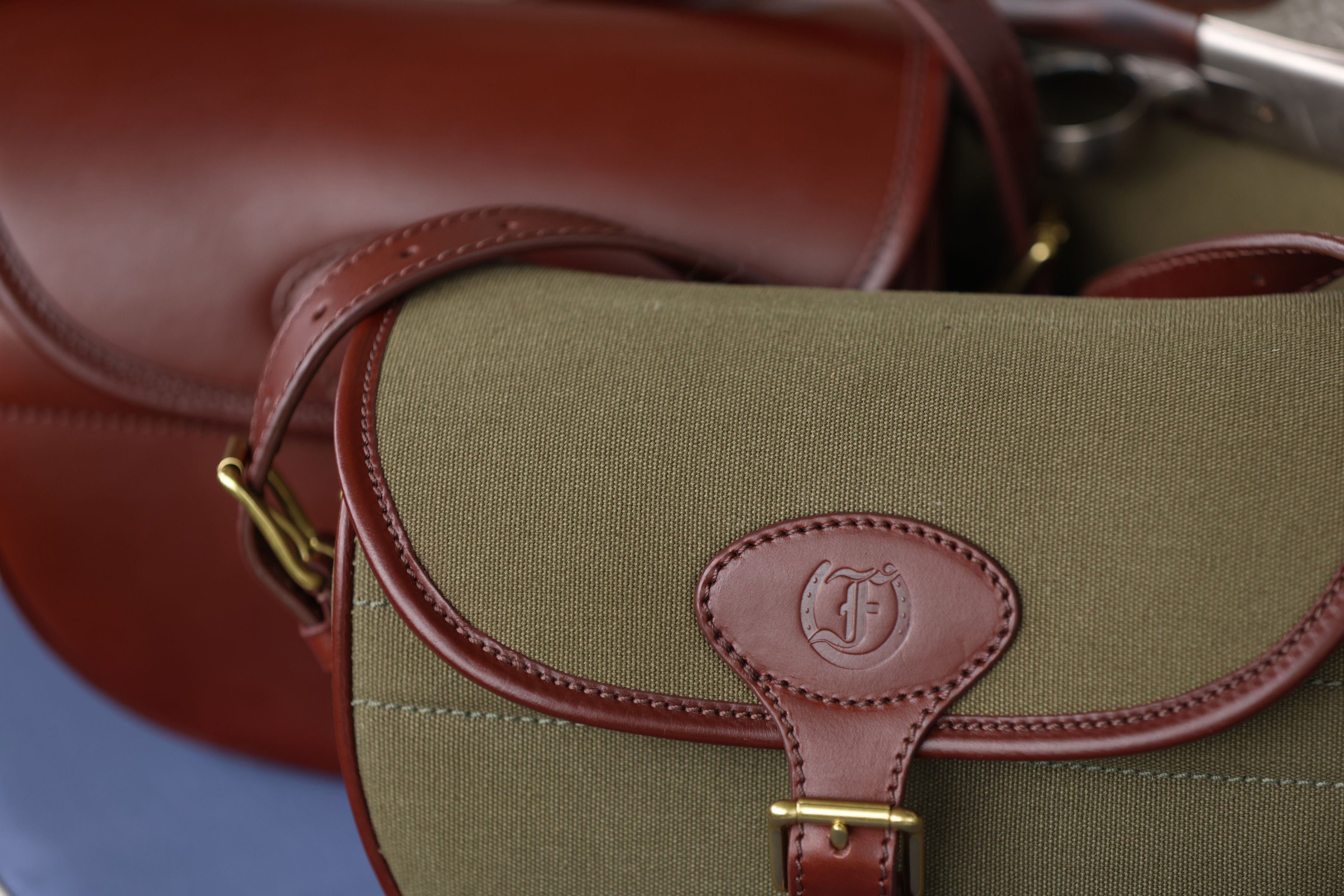 Close-up of the Military Green Ashcombe Cartridge Bag with Havana brown leather trim and embossed “F” logo, made by Freedman’s Harness.
