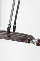 Close-up of an ACTraining Breast Collar and Neck Strap component, showing brown leather construction, buckles, rings, and stitching details, isolated on a white background.
