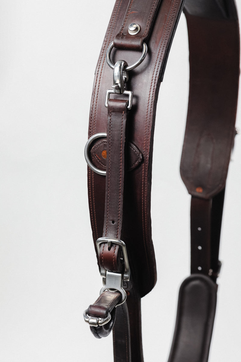 Close-up of the quick-release mechanism on a Freedman's Quick Hitch Jog Harness, showing leather straps, metal rings, and buckles, isolated on a white background.