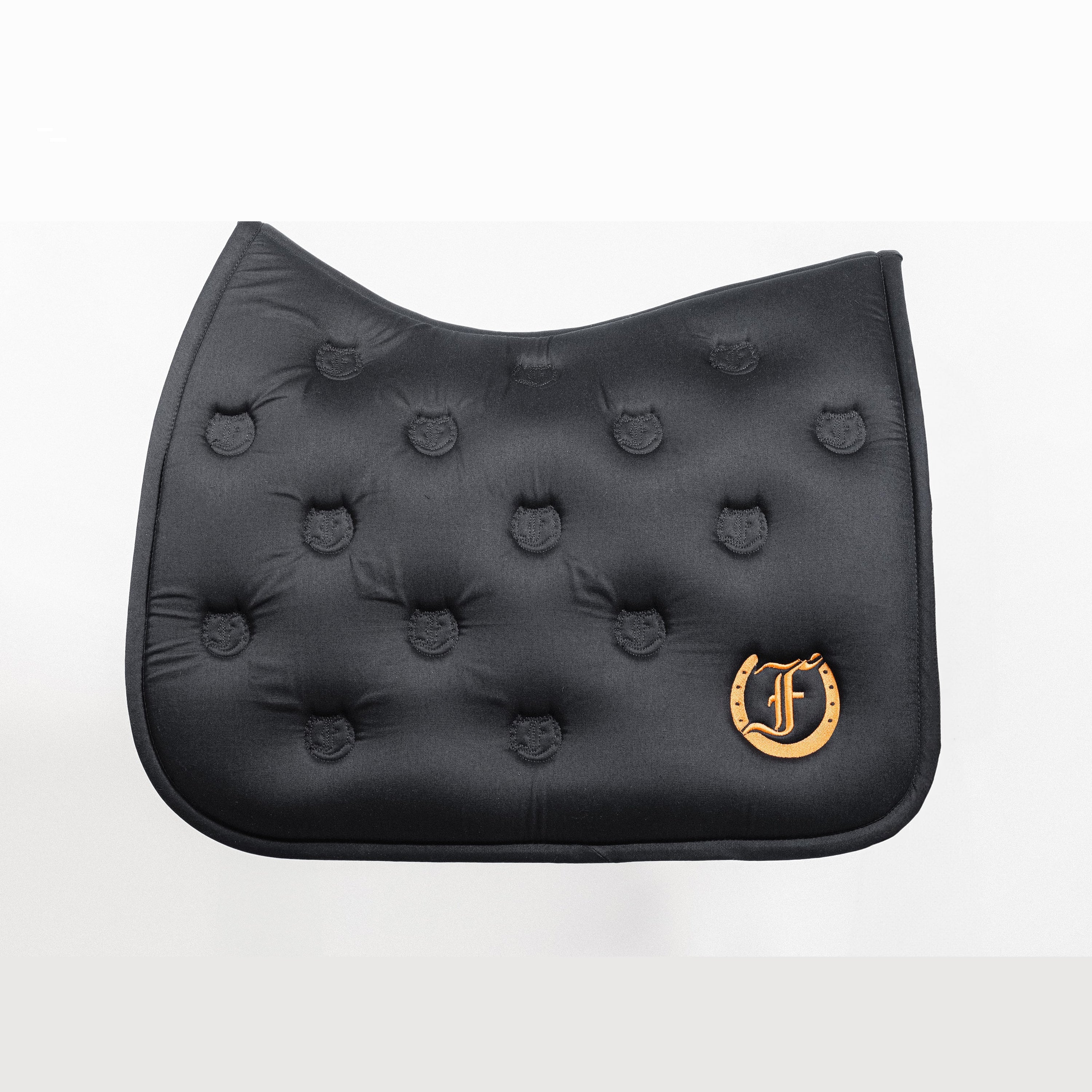 Black quilted saddle pad with a soft and absorbent bamboo lining, featuring an embroidered Freedman's logo, shown on a white background