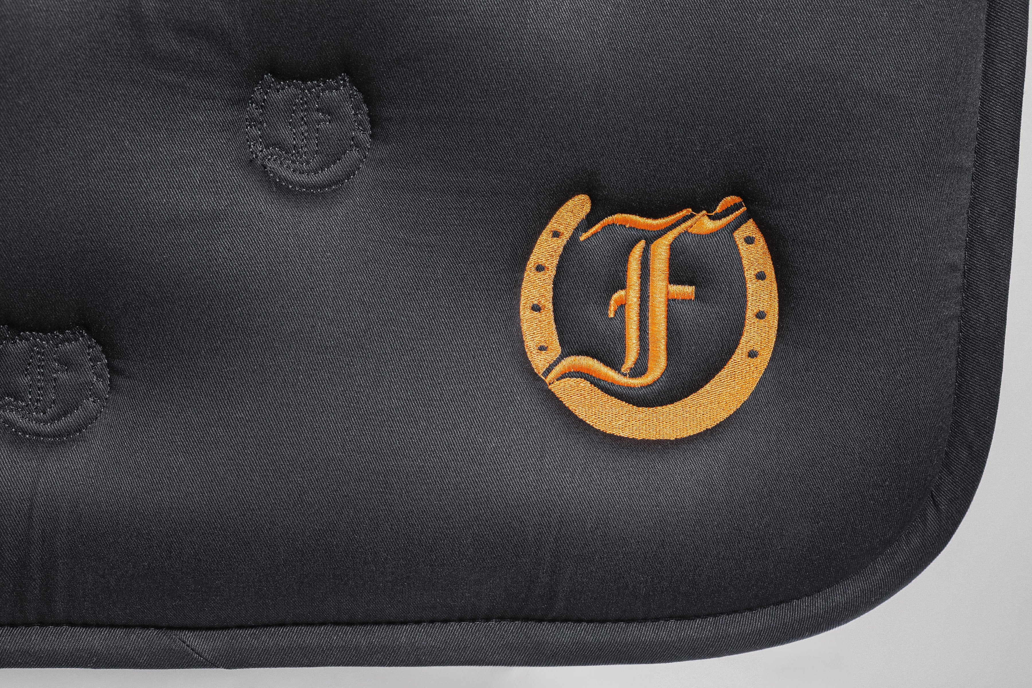 Detailed view of the Freedmans's logo and the Freedman's logo pattern quilting on a black saddle pad.