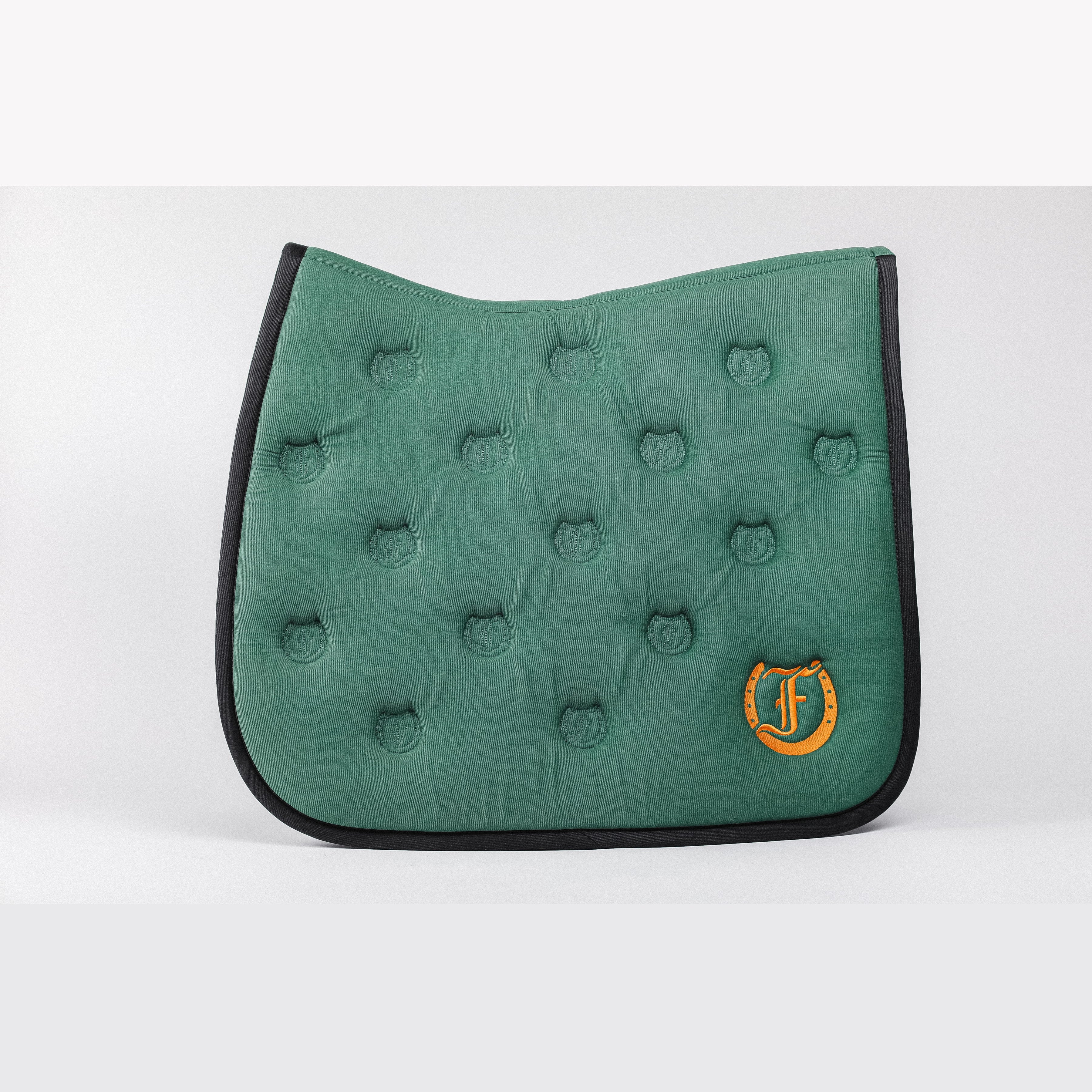Green quilted saddle pad, showcasing the bamboo lining, Freedmans's logo embroidery, and Freedmans's logo pattern quilting.