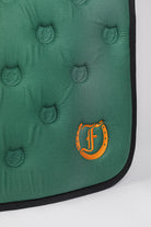 Detailed view of the Freedman’s logo and the Freedman’s logo pattern quilting on a green saddle pad.