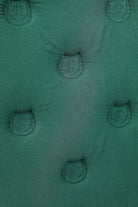 Detailed view of the Freedman’s logo patterned quilting on a green saddle pad.