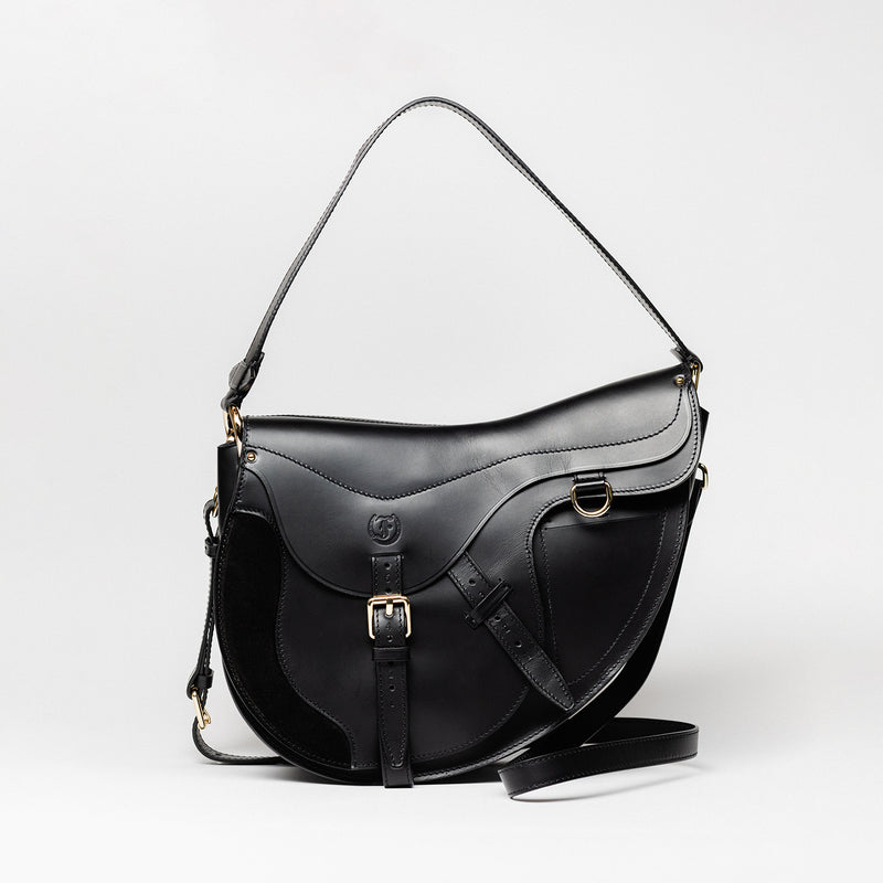 Freedman’s Burghley Shoulder Bag in black leather, featuring gold finished hardware, a distinctive saddle-inspired silhouette, and an adjustable shoulder strap, on a white background. 