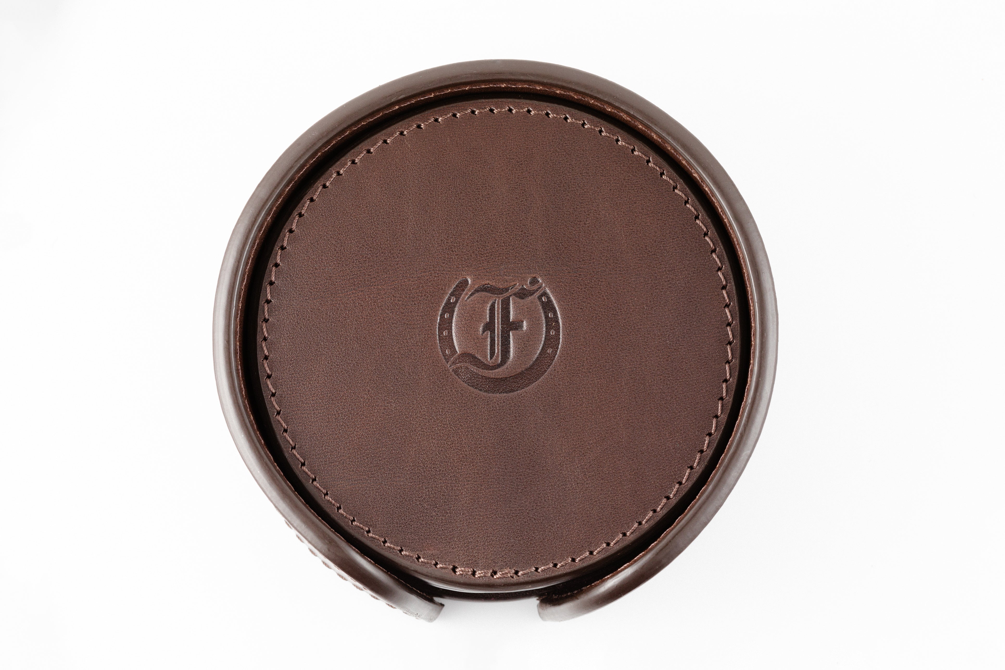 Freedman's Coaster Set in Holder: Brown Leather Coasters with Embossed Freedman’s Logo in Center, Close-Up View