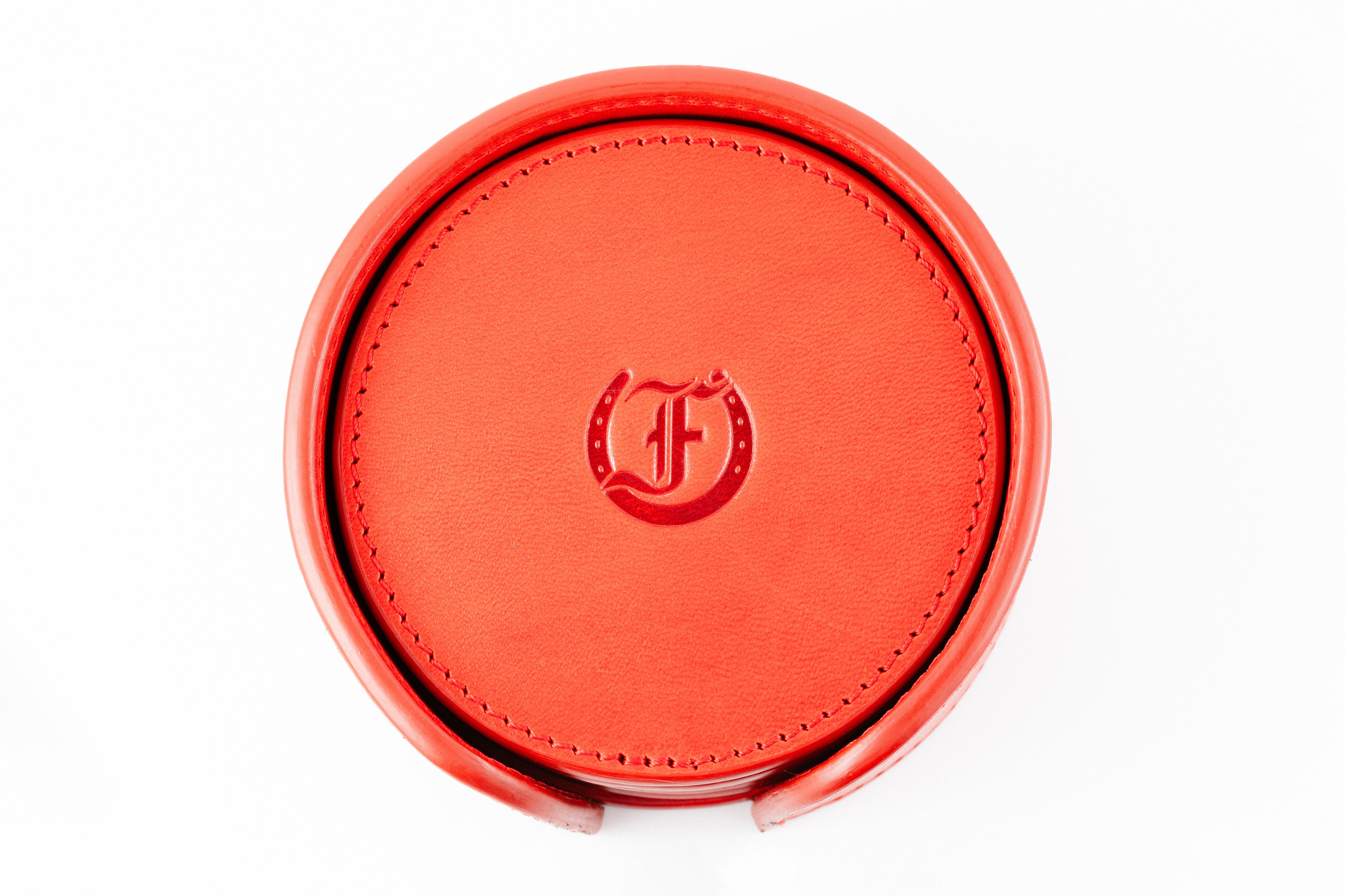 Freedman's Coaster Set in Holder: Red Leather Coasters with Embossed Freedman’s Logo in Center, Close-Up View