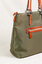 Freedman's Conestoga Tote in olive green, detailed side view showcasing the bag's shape, back zipper pocket with red zipper teeth, brown leather handles with silver hardware, and the bag's smooth fabric texture