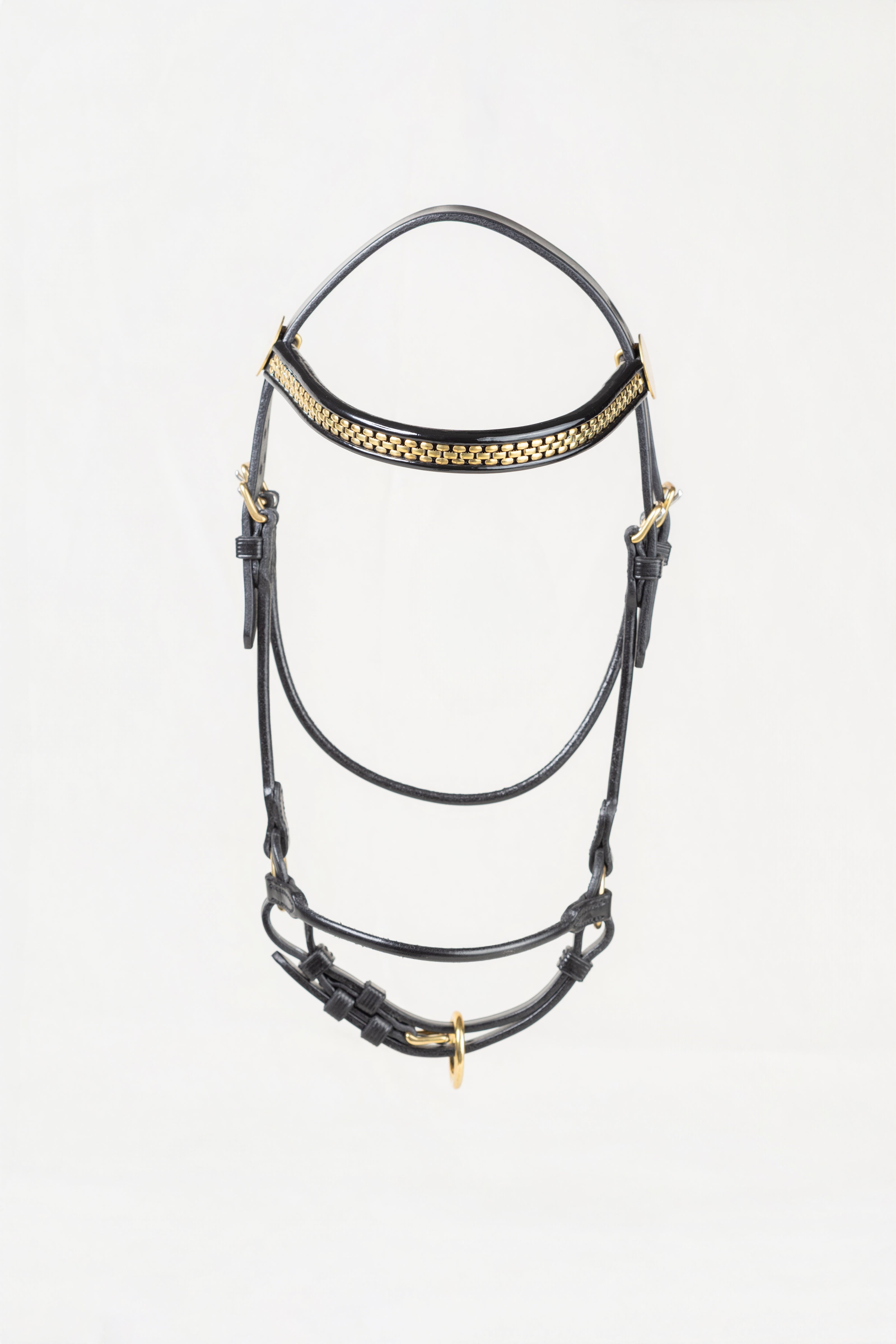 A black leather horse bridle with gold-tone metal hardware and a decorative gold patterned band across the forehead, shown against a plain white background.