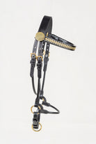 Black leather horse bridle with gold-tone metal accents and a decorative gold patterned bit, shown against a plain white background.