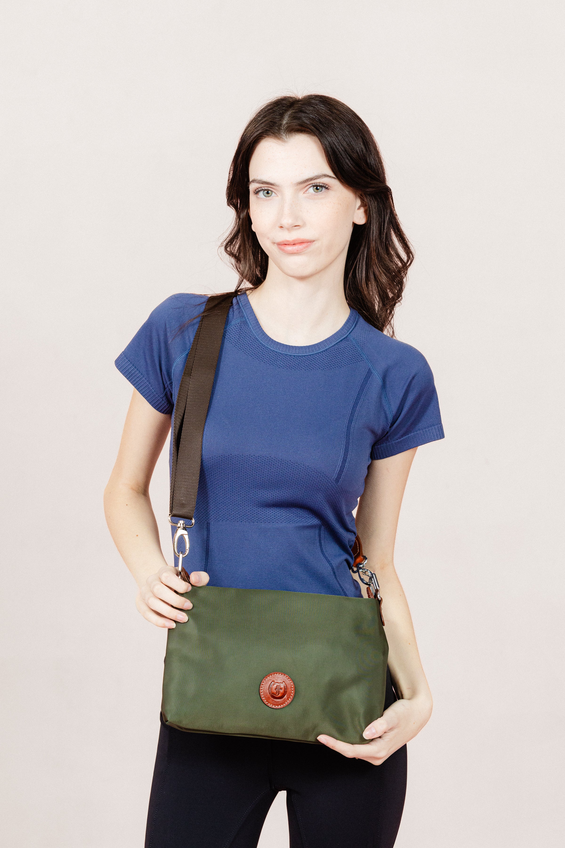 Fashion model showcasing the Dokar bag with a casual outfit of a Navy Blue t-shirt and black jods on a clean white backdrop.