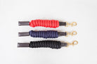 Three Freedman Harness paracord poly and leather snap lead ropes in red, blue, and black, featuring premium Brass hardware on a white background.
