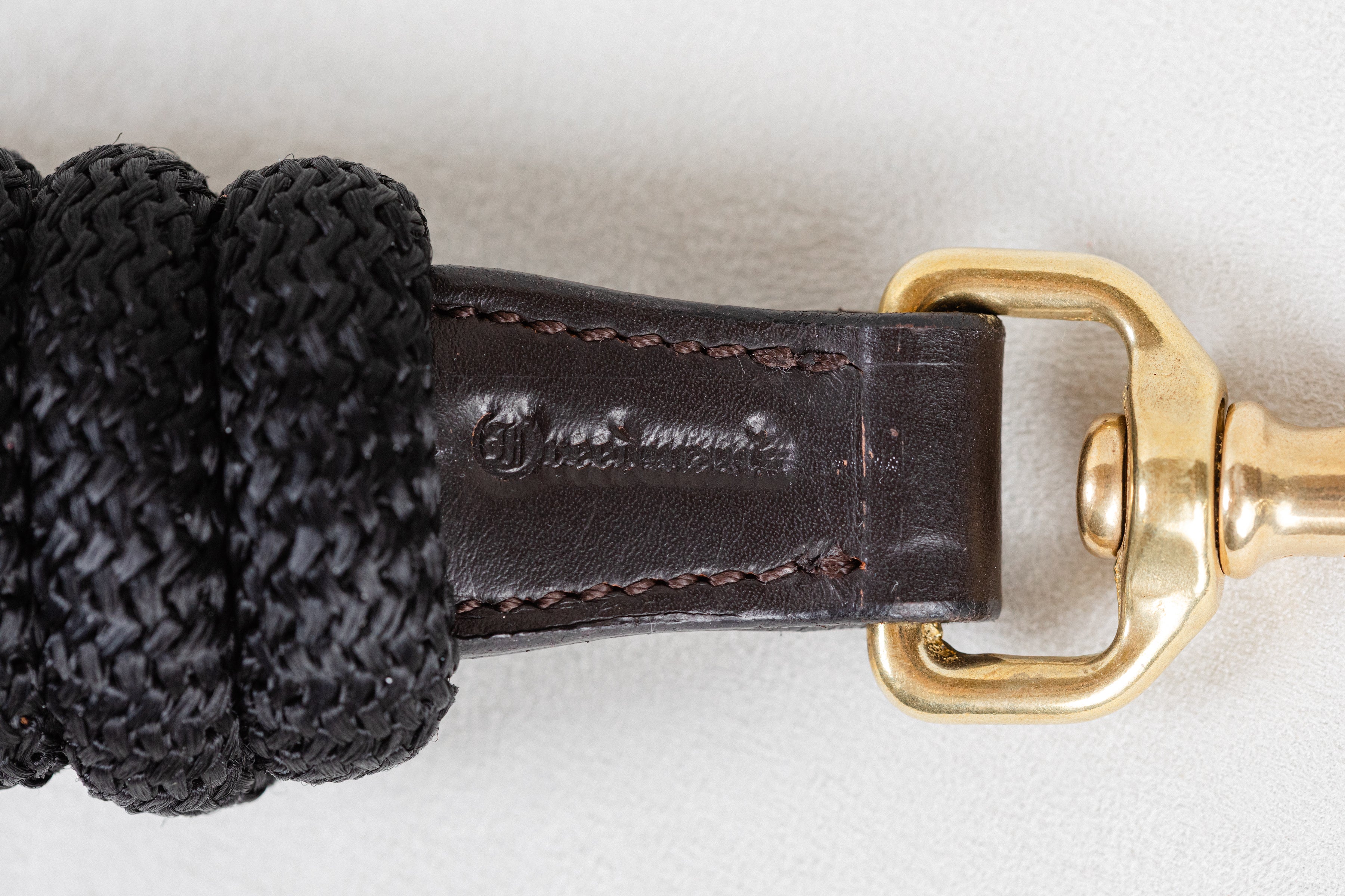 Detailed close-up of the leather on a Freedman Harness black lead rope, showcasing Freedman's logo on a white background
