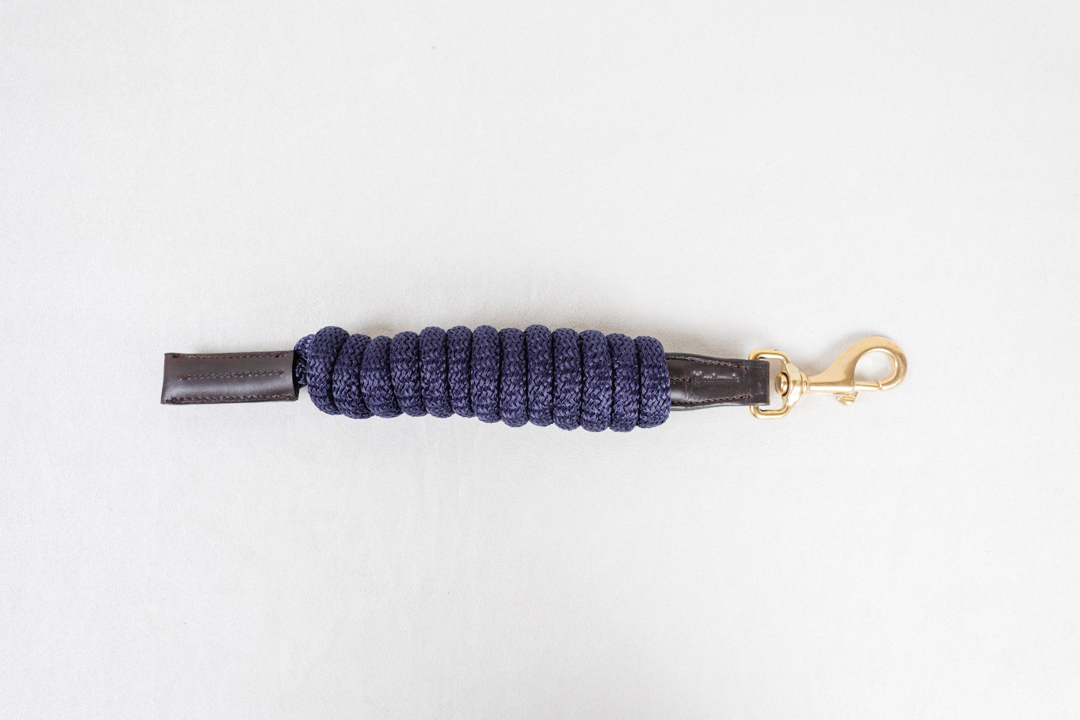 Freedman Harness Navy paracord poly lead rope with premium brown leather accents and a brass snap on a white background.