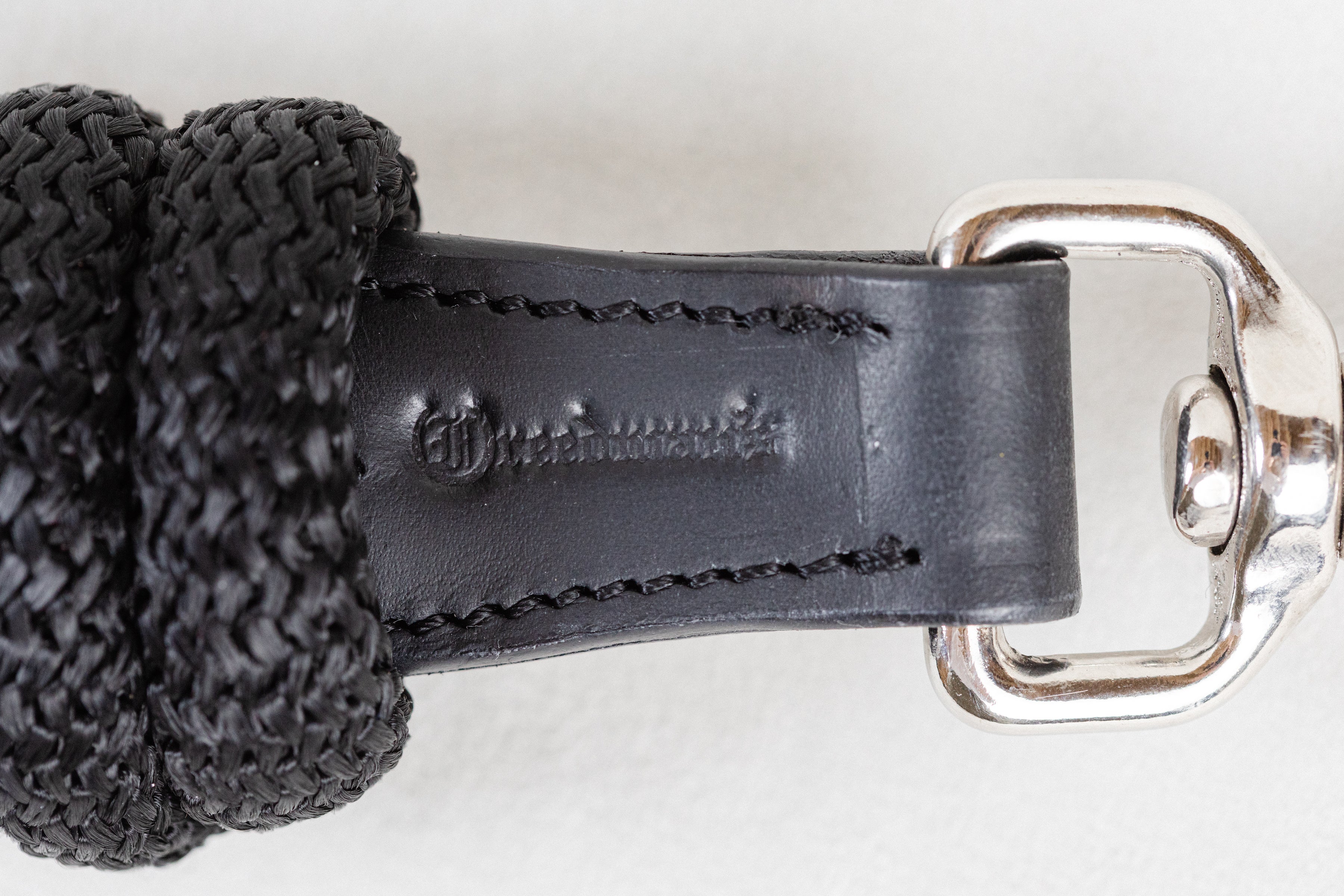 Detailed close-up of the leather on a Freedman Harness black lead rope, showcasing Freedman's logo on a white background
