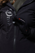 Close-up of a person wearing a black Freedman's jacket with a large logo and black Polartec gloves with visible logo.