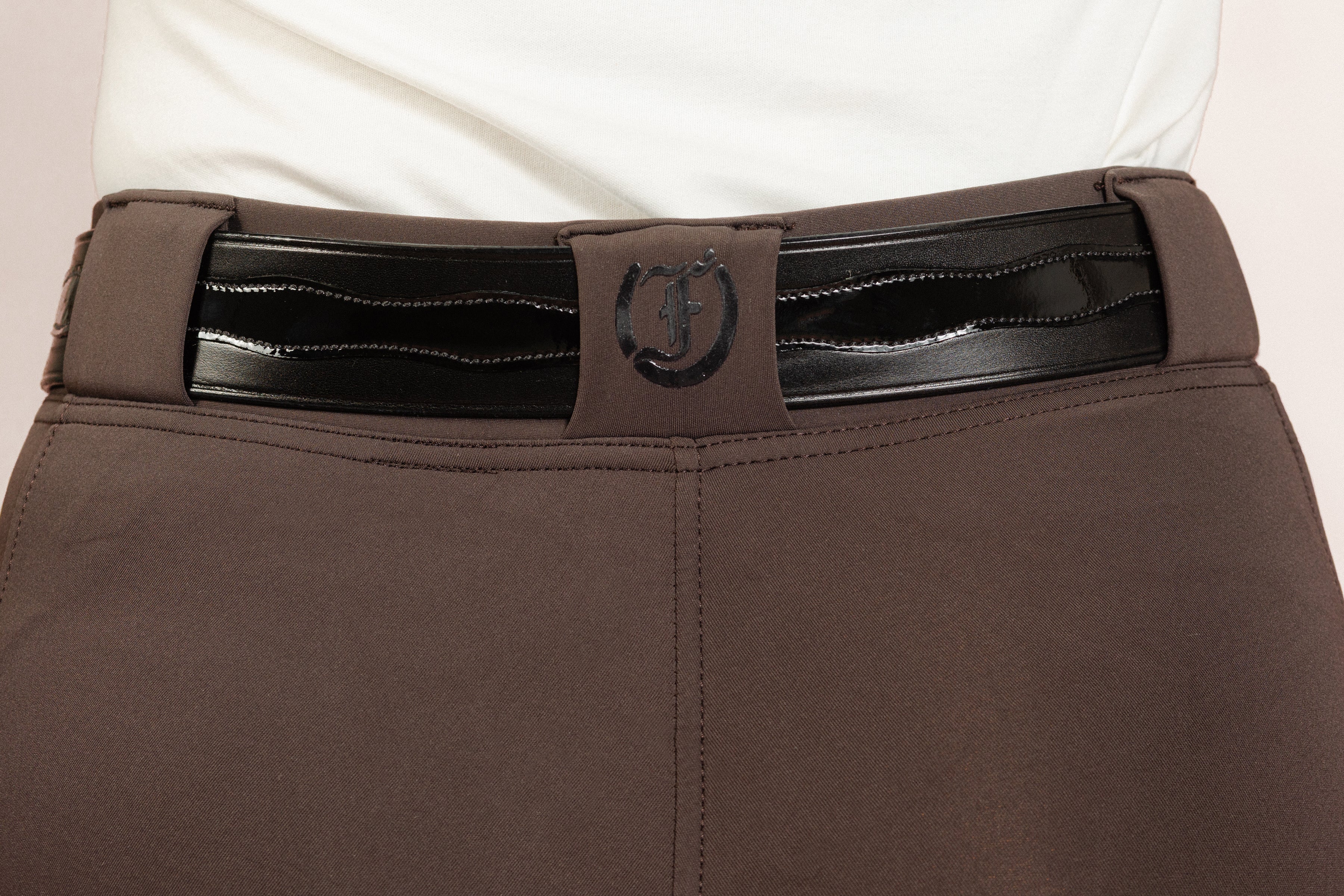 Back view of After Dark Brown Jods with a Patent Scalloped Spur Belt and Freedman’s “F” logo by Freedman’s Harness on a beige background.