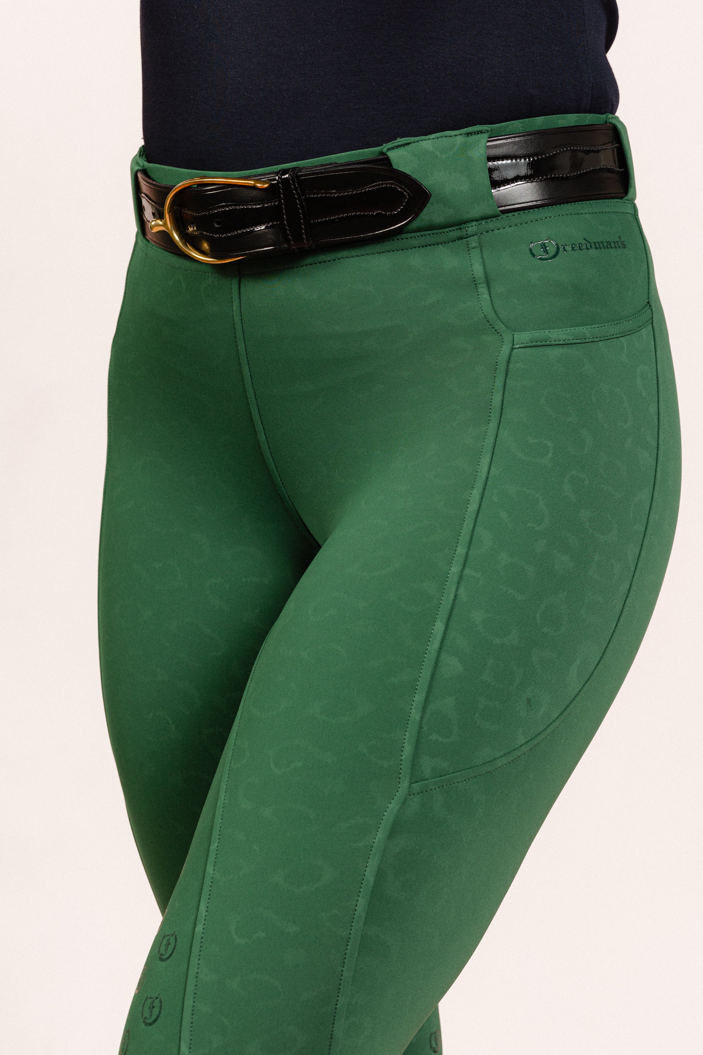 Green Cheetah Jods showing the “Freedman’s” logo with a Patent Scalloped Spur Black Belt on a white background, made by Freedman’s Harness.