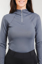 Woman wearing the Tess Ladies' 1/4 Zip Long Sleeve Top by Freedman's in a stylish grey colour, designed for comfort and performance in equestrian and activewear fashion.