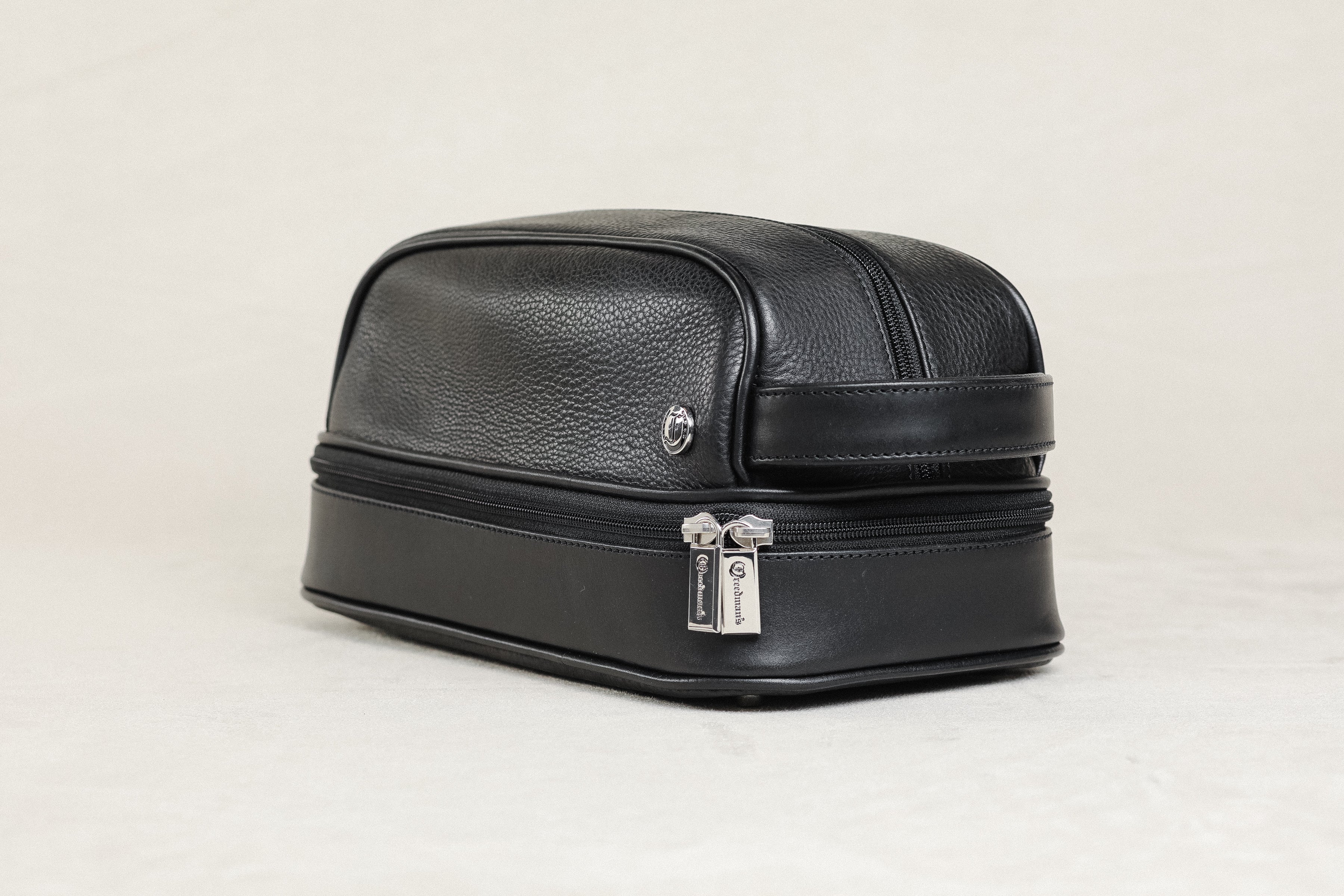 Freedman's Cardiff Shave Bag, Black Textured Leather, Dual Zippered Compartments with Red Fabric Lining and Embossed Logo Pattern, Silver Hardware, and Side Handle