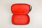 op-down view of open Freedman's Cardiff Shave Bag, black leather exterior visible, bright red fabric lining in both compartments with repeated embossed Freedman's "F" logo pattern, open zipper, light background.