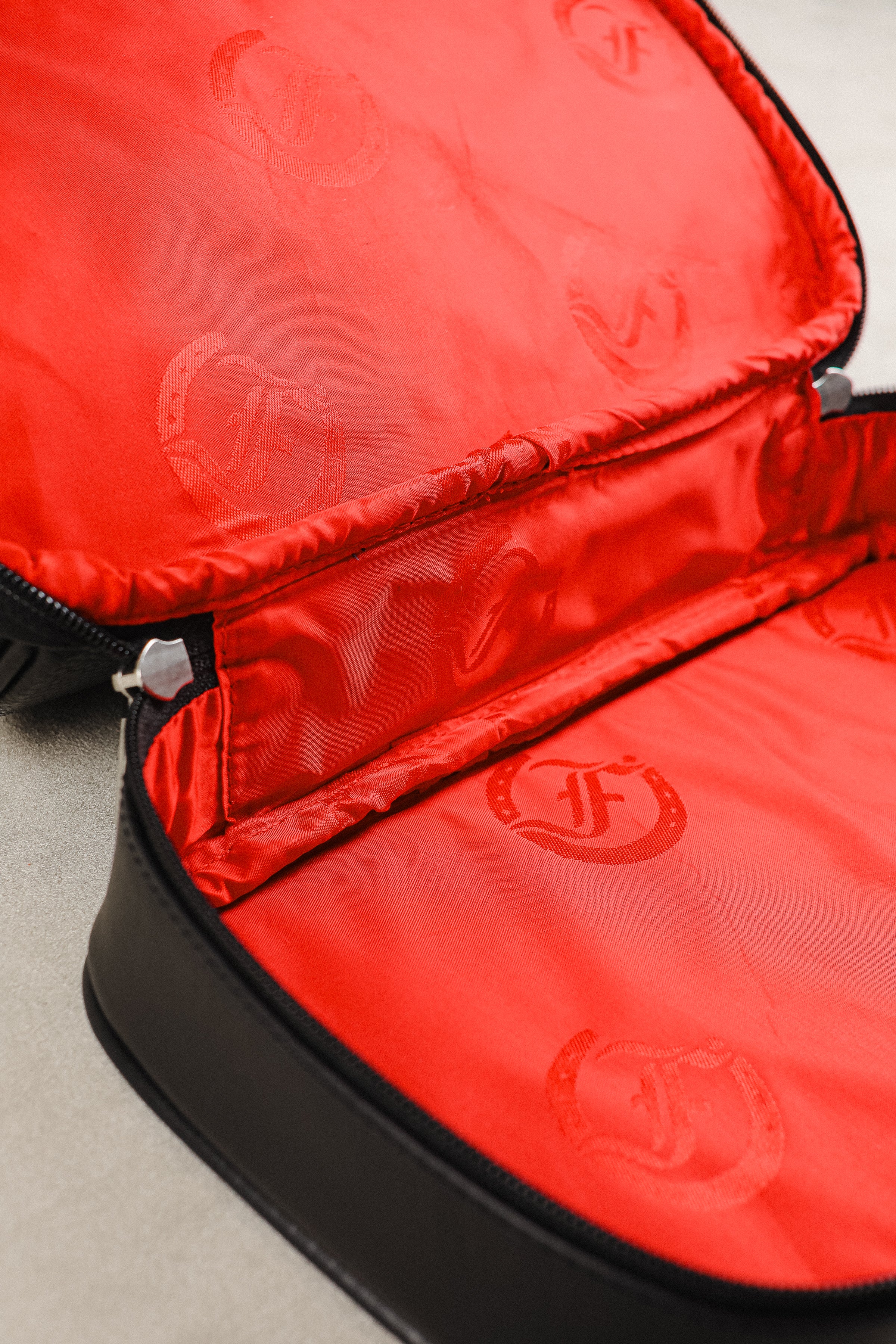 Interior view of black leather shave bag, Cardiff model by Freedman's, with red fabric lining and logo print.