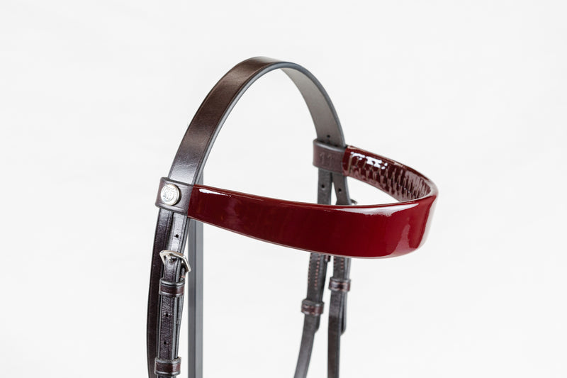 Close-up of Freedman’s burgundy leather bridle straps showing the embossed logo stamp and stainless steel buckle hardware.