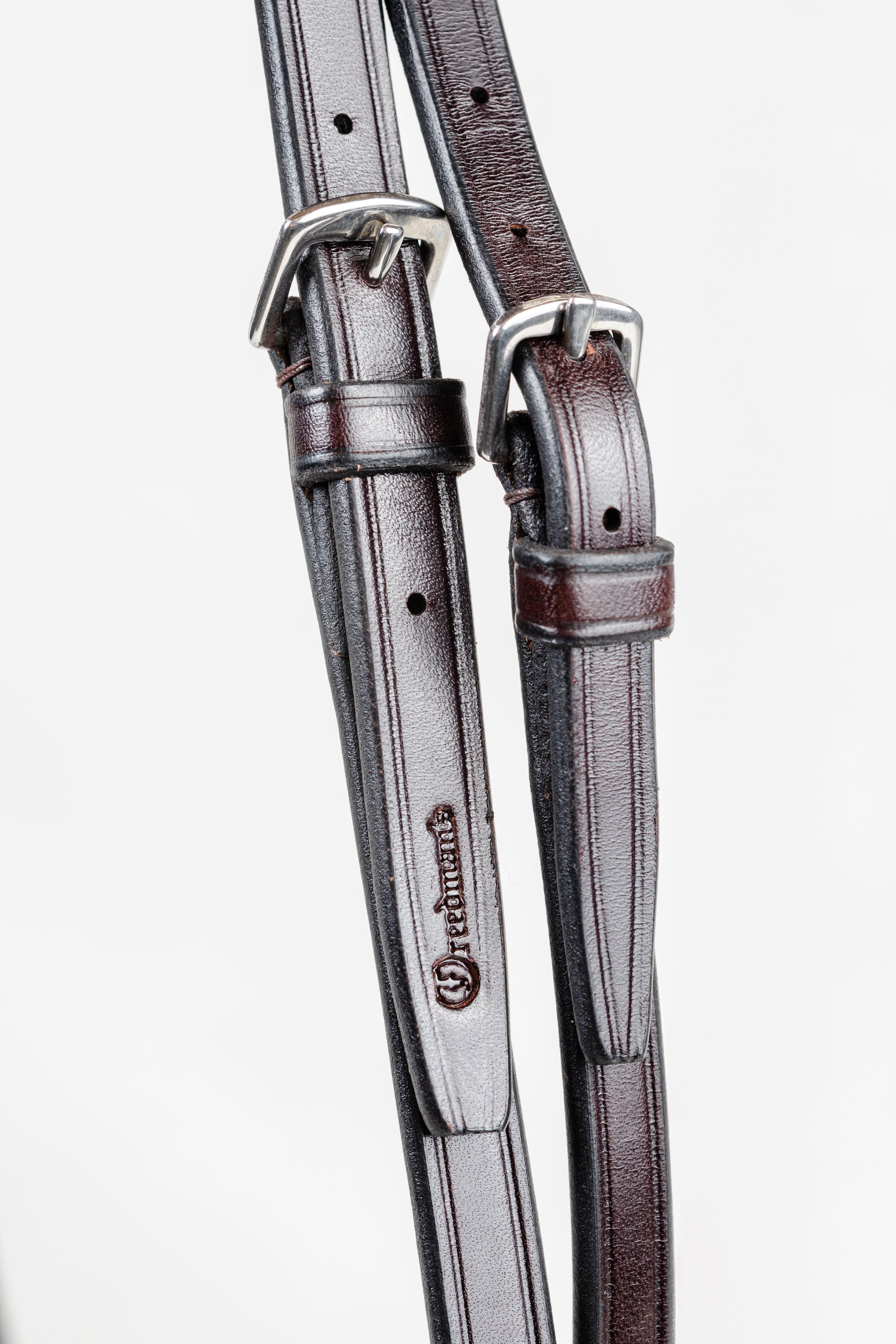 Two leather straps with a silver buckle on a white background