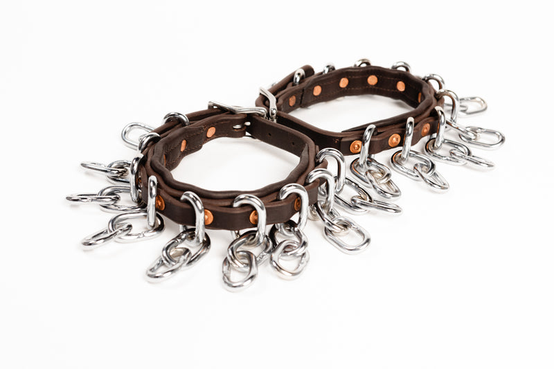 Close-up of ACTraining ankle action chain straps showing leather, buckles, and hanging chains.