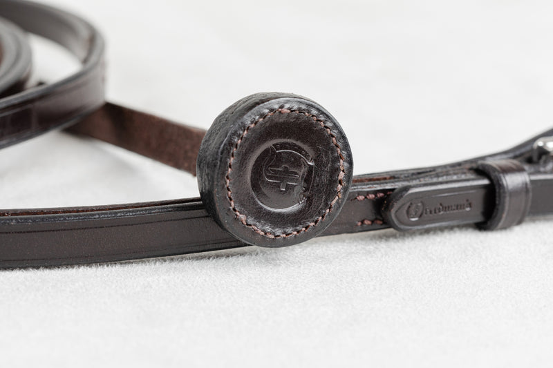 Close-up of the leather handhold on a Freedman Harness Show Lead, featuring an embossed 'F' logo, precision perimeter stitching, and rich dark brown leather on a white background.